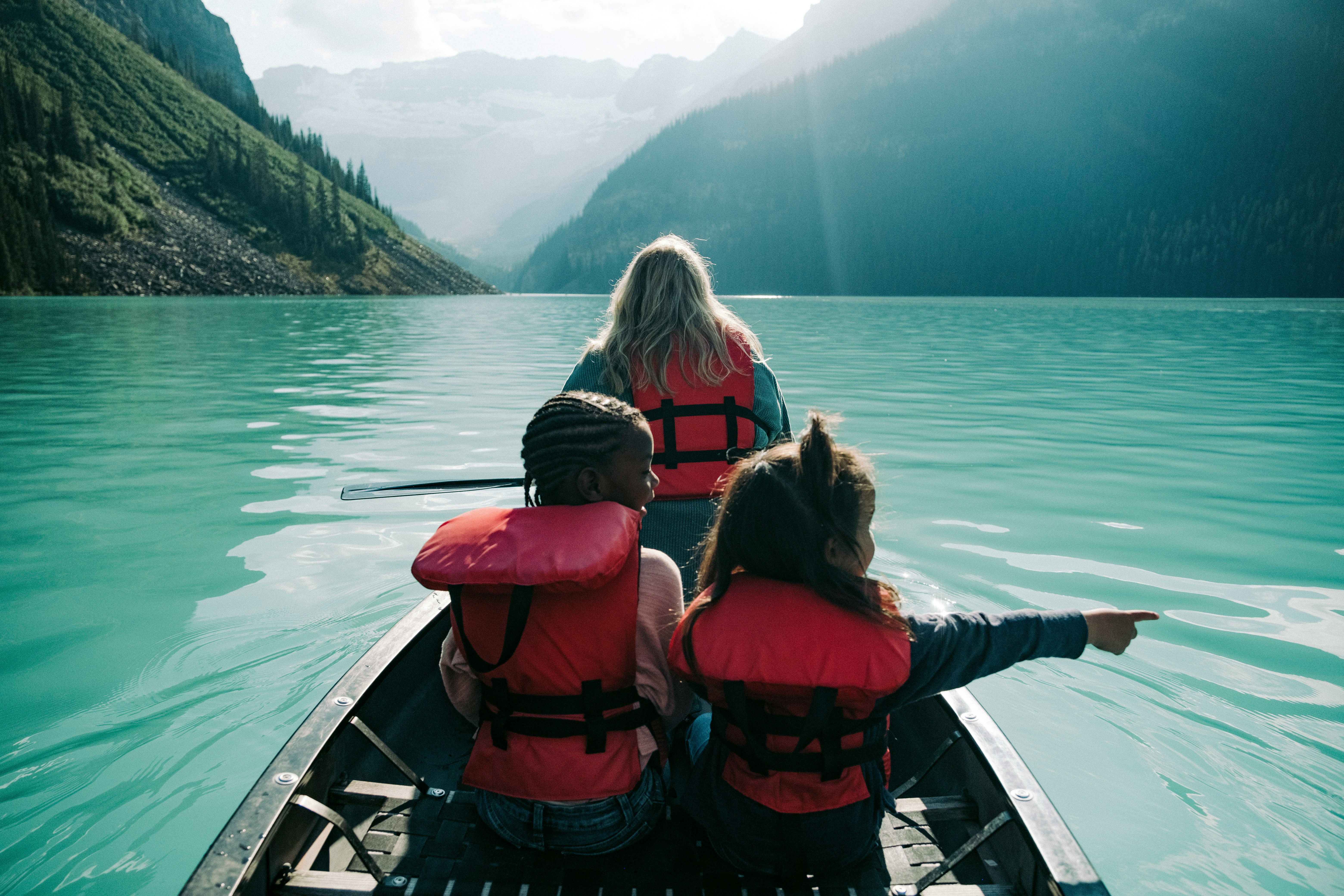 two children and one adult on a small boat on water