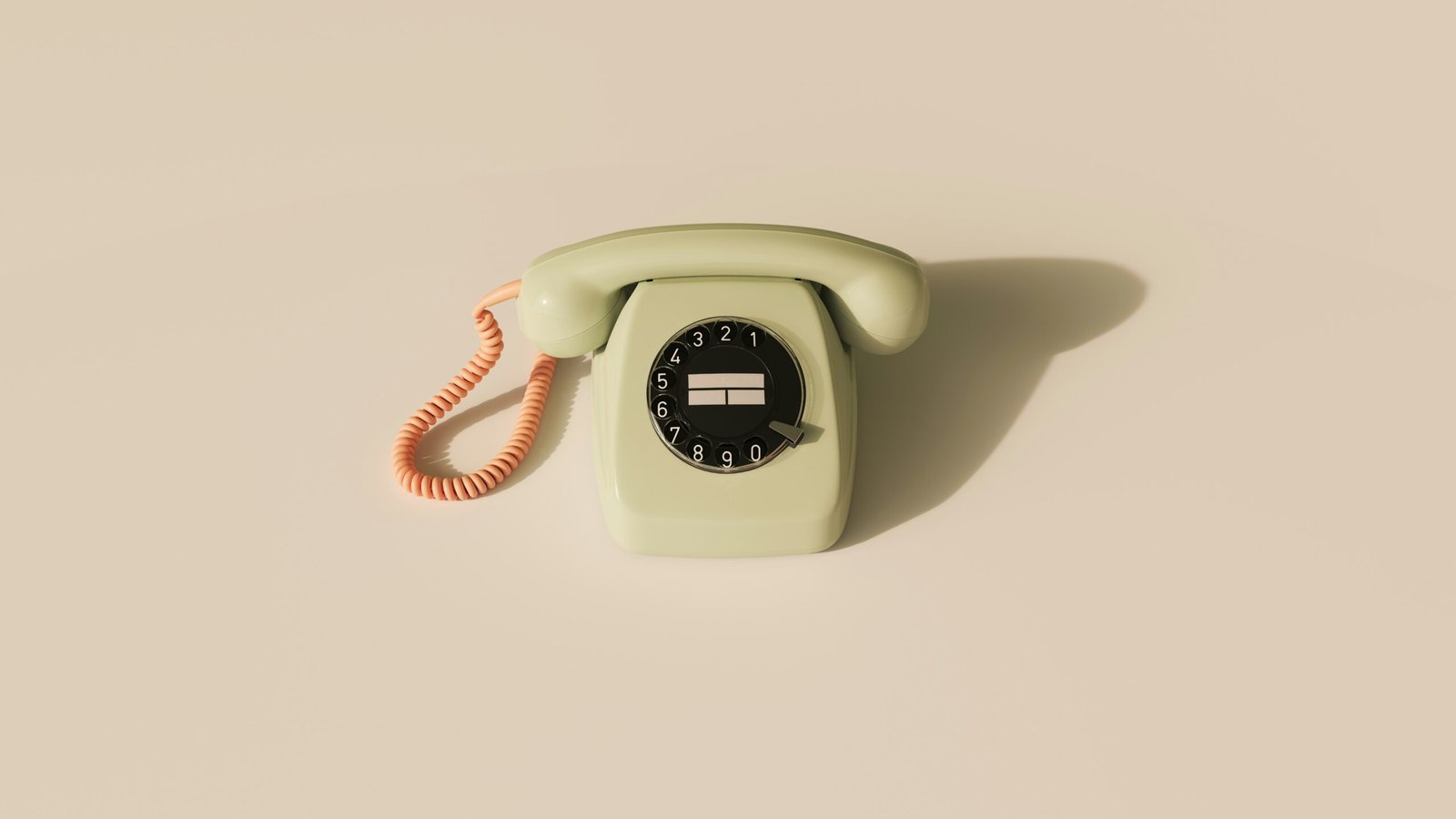 an old fasioned light green telephone with an orange cord